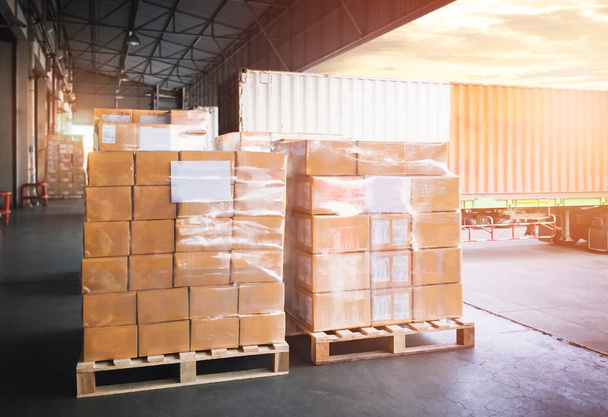 Packaging Boxes on Pallets Loading into Shipping Cargo Container. Delivery Trucks Parked Loading at Dock Warehouse. Supply Chain Customers Shipment Logistics. Cargo Freight Truck Transport. - Photo, Image