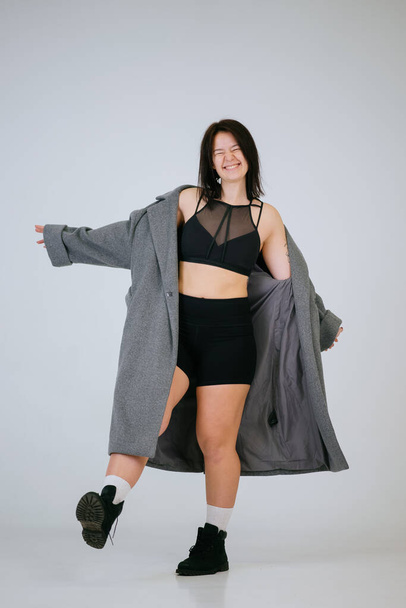 Плюс размер тела положительная женщина в удобном нижнем белье и пальто - Фото, изображение