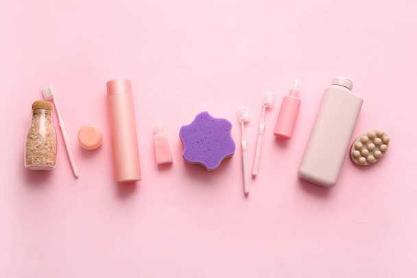 Bouteilles de produits cosmétiques et différentes fournitures de bain sur fond rose - Photo, image