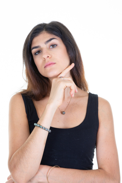 молода жінка брюнетка мислення рукою пальцем на підборідді на білому фоні дивиться камеру
 - Фото, зображення