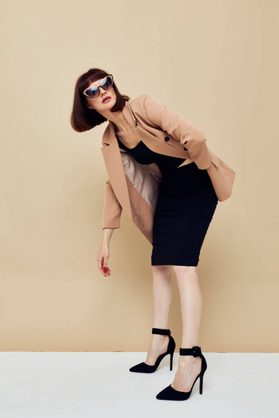 attractive woman in a beige jacket elegant style sunglasses isolated background - 写真・画像