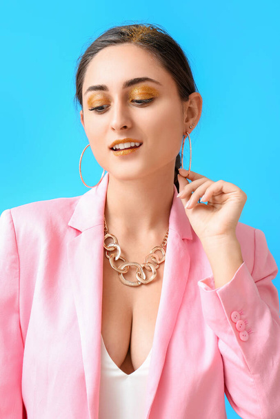 Attractive young woman with unusual shiny makeup on blue background - Φωτογραφία, εικόνα
