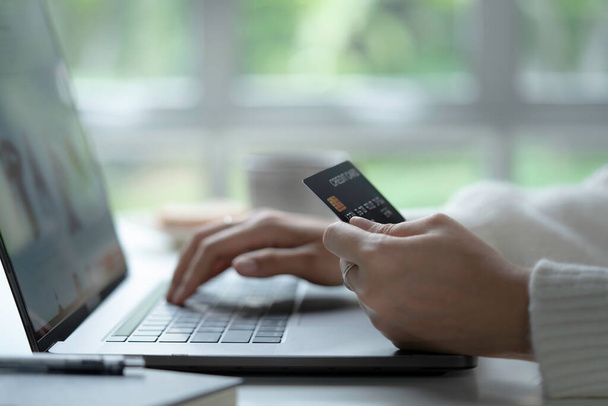 Female hands holding credit card and using laptop. Online shopping - Fotografie, Obrázek
