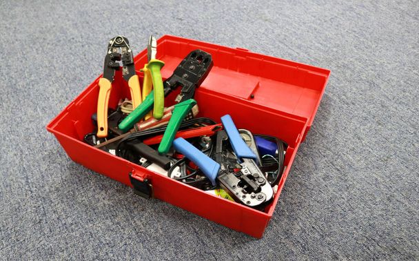 Φωτογραφία από μια κόκκινη εργαλειοθήκη γεμάτη εργαλεία για τους εργαζόμενους - Φωτογραφία, εικόνα