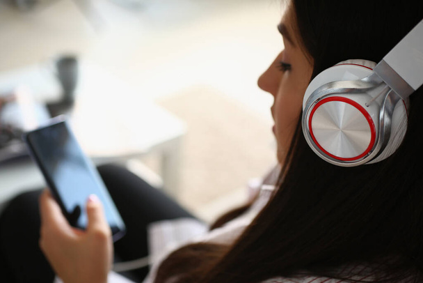 Woman wear headset and watch movie or listen to music on smartphone - Zdjęcie, obraz