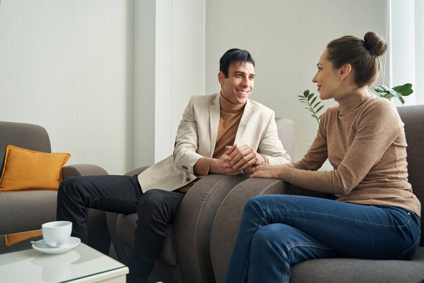 Happy Caucasian couple sitting in hotel room - Zdjęcie, obraz