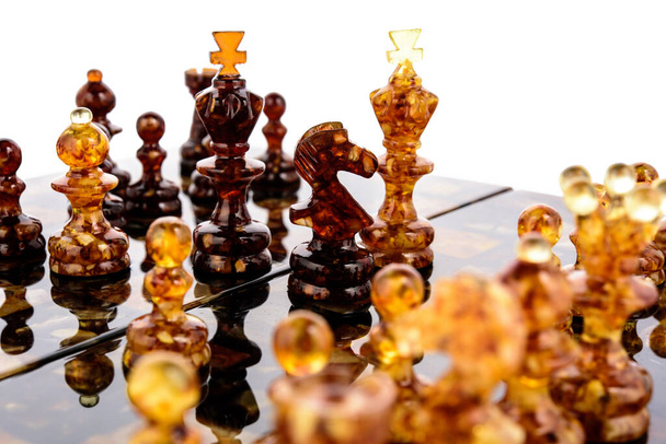 âmbar natural diferentes peças de xadrez figuras de pé na placa de superfície laca - Foto, Imagem