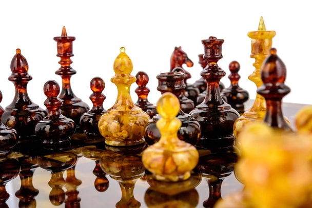 Naturalne bursztynowe figury szachowe stojące na powierzchni lakieru - Zdjęcie, obraz