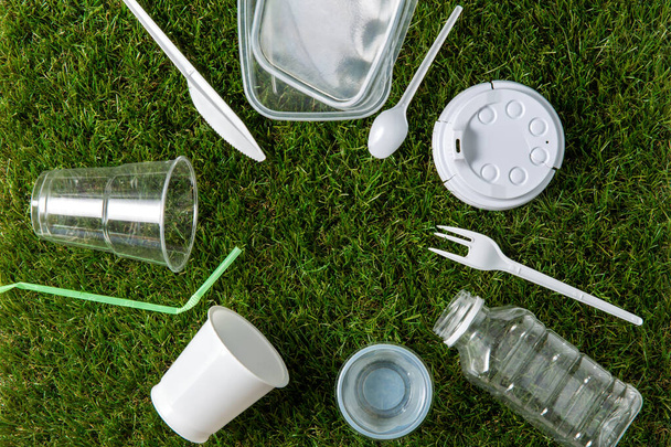 close up of plastic waste on grass - Foto, afbeelding
