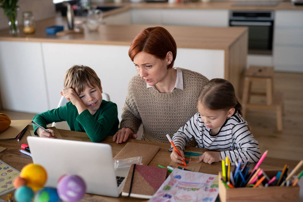 Mother of little children supervising them when distance learning and doing artwork at home. - Φωτογραφία, εικόνα