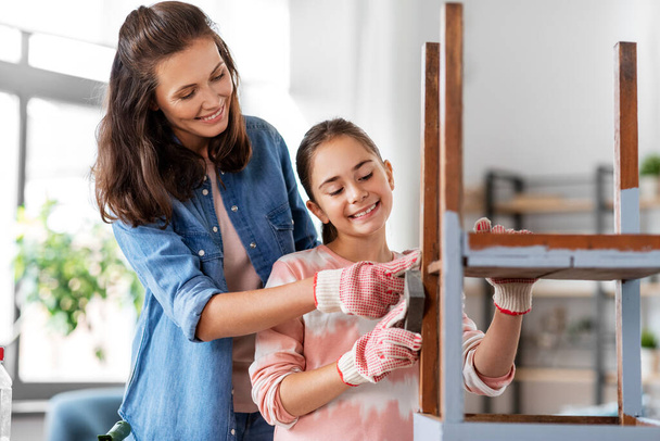 mother and daughter sanding old table with sponge - Foto, Bild