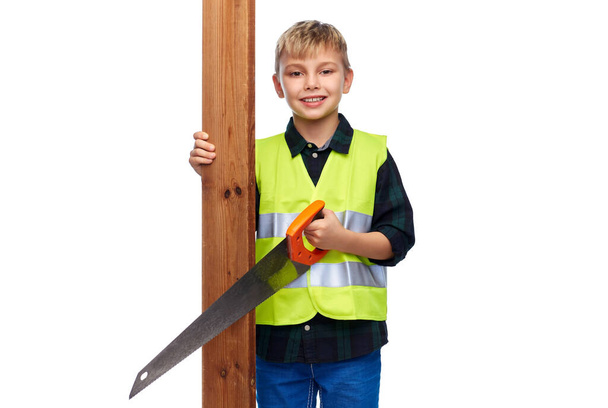 little boy in safety vest with saw and board - Foto, imagen
