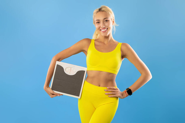 Portrait of Sporty Woman Holding Scales. Slimming Concept - Photo, Image