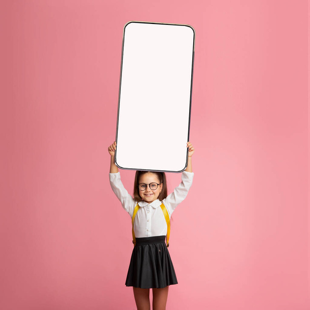 Menina da escola mostrando branco tela do smartphone vazio - Foto, Imagem