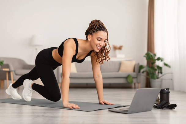 Feminino Perto Laptop Fazendo Treinamento de Exercício de prancha em casa - Foto, Imagem