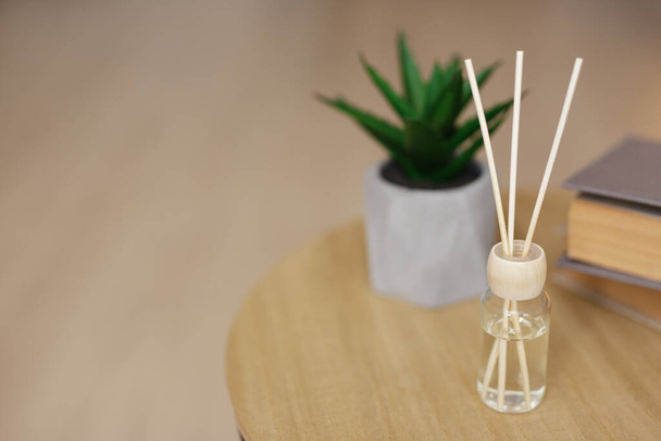 home and interior - close up of reed diffuser on wooden table and copy space - Photo, Image