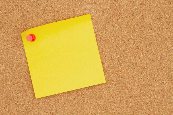 Blanco gele kleverige notitie op een prikbord voor uw bedrijf of vacature - Foto, afbeelding