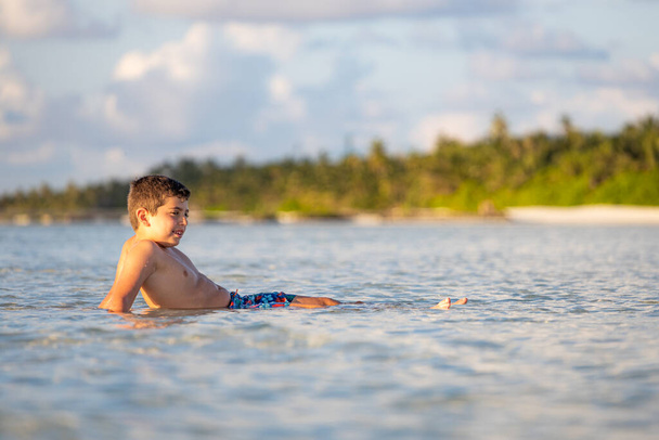 Relaxed boy lying on water of the Indian ocean - 写真・画像