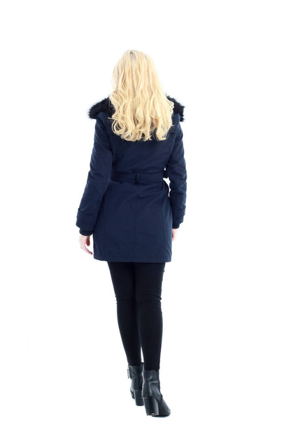 Ganzkörperporträt einer blonden Frau im langen Wintermantel. und Freizeitkleidung. stehend, isoliert auf weißem Studiohintergrund. - Foto, Bild