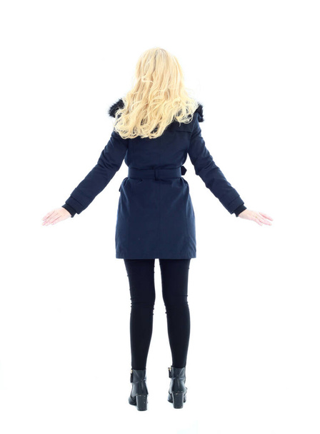 täyspitkä muotokuva blondi nainen yllään pitkä talvi takki. ja vapaa-ajan vaatteita. seisova poseeraus, eristetty valkoisella studion taustalla. - Valokuva, kuva