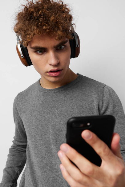 handsome young man looking at the phone headphones fashion Lifestyle unaltered - Fotografie, Obrázek