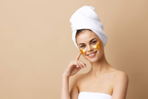 jonge vrouw gouden vlekken schone huid glimlach poseren geïsoleerde achtergrond - Foto, afbeelding