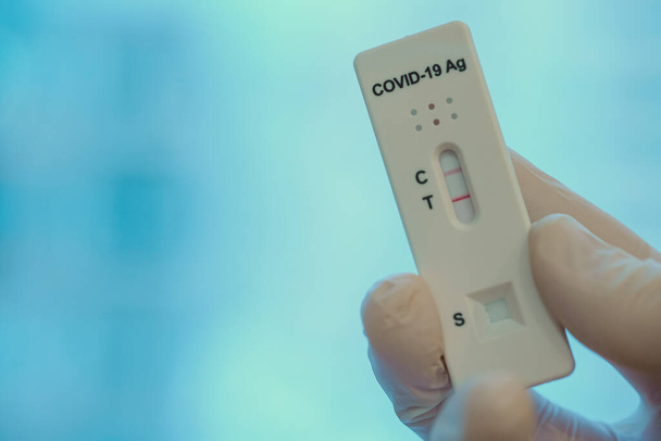 Virologue montrant un test rapide antigène positif pour le coronavirus. - Photo, image