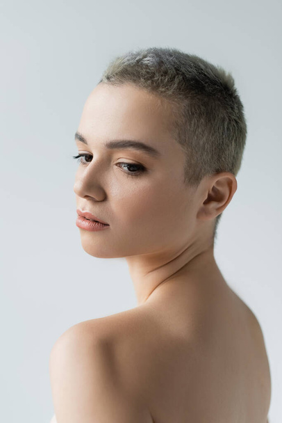 young woman with short hair and naked shoulders isolated on grey - Foto, immagini
