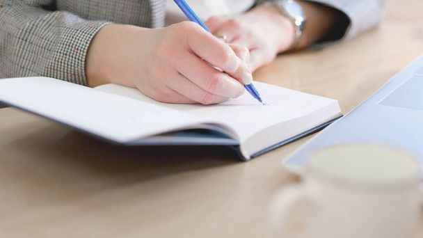 Ofiste çalışan bir iş kadını, masasında belgelerle çalışan bir iş kadını, elinde kalem ve kağıtlarla masanın üzerine notlar yazan bir iş kadını, finans müdürünün elleri not tutuyor.. - Fotoğraf, Görsel