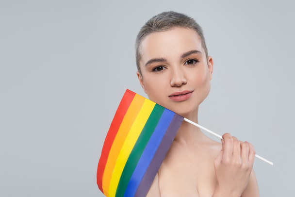 pretty woman with small lgbt flag looking at camera isolated on grey - Foto, afbeelding