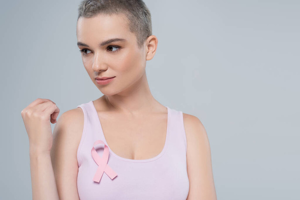 pretty woman with pink awareness ribbon on tank top looking away isolated on grey - Fotoğraf, Görsel