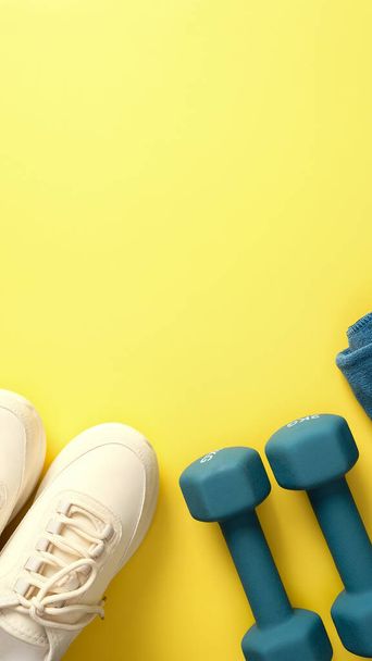Feminine sport workout equipment on yellow background. Active lifestyle concept. Sport blog vertical banner design. - Foto, imagen