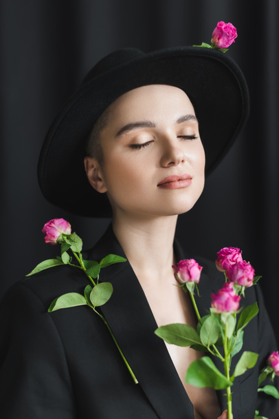pretty woman with natural makeup, closed eyes and pink tiny roses on black  - Fotoğraf, Görsel