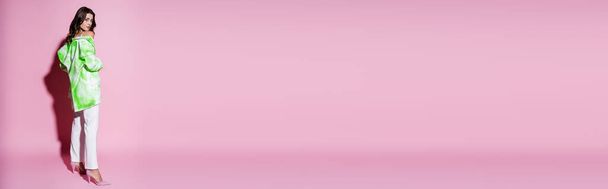 Полная длина брюнетка женщина в стильном наряде позируя на розовый, баннер - Фото, изображение