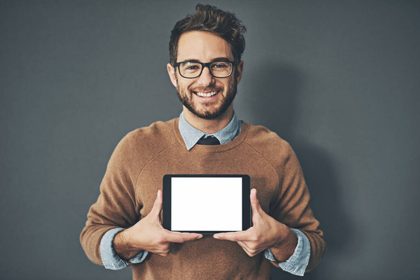 Можливо, настав час перенести ваш бізнес онлайн. Студійний портрет молодого чоловіка, який тримає цифровий планшет з порожнім екраном на сірому фоні
. - Фото, зображення