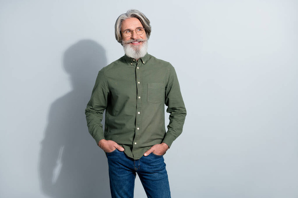 Portrait of attractive cheery minded grey-haired man thinking copy space isolated over gray pastel color background - Fotó, kép