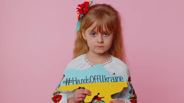 Portrait of Ukrainian girl child with massage inscription text on map Hands Off Ukraine, crisis, war - Photo, Image