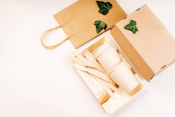 Eco craft paper tableware,cups,fast food containers.Recycling,eco-friendly concept.Disposable eco cutlery,plates,spoons,knives,forks on a light background.Craft paper bag for food delivery.Copy space. - Photo, Image