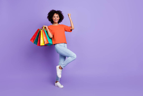 Full size photo of shopaholic smiling girl raise fists in victory triumph love big sales isolated on violet color background - Фото, зображення