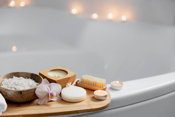 Tratamiento de spa del hotel o procedimiento de baño en casa. Cuarto de baño con accesorios en bandeja - Foto, imagen