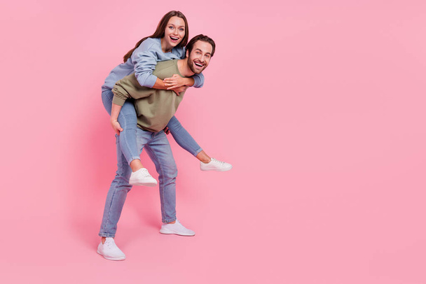 Full body profile portrait of two carefree people carry piggyback enjoy free time isolated on pink color background - Foto, Bild