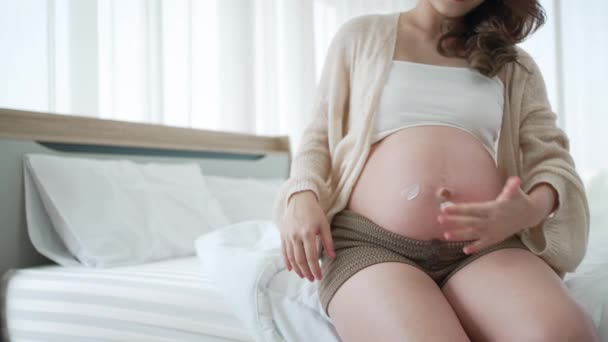 Mujer Asiática Embarazada Aplicar Anti Stretch Mark Belly Cream para prevenir cicatrices en el abdomen - Metraje, vídeo