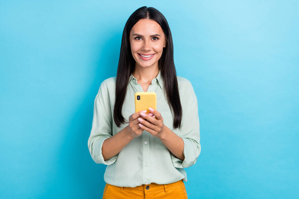 Photo of charming good mood businesswoman surfing online texting friends isolated on blue color background - Foto, imagen