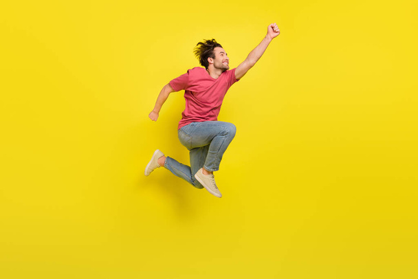 Full length profile photo of hooray beard millennial guy fly wear red t-shirt jeans footwear isolated on yellow background - Photo, Image