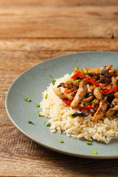 Pork chop with peppers, mushrooms and bamboo. Served with rice. Front view. - Valokuva, kuva