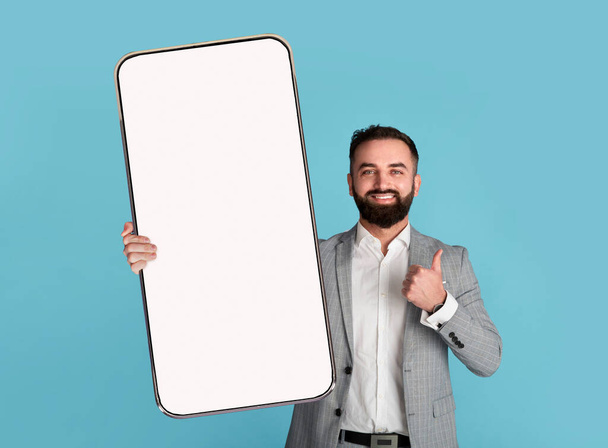 Hombre mostrando blanco pantalla vacía del teléfono inteligente, maqueta - Foto, Imagen
