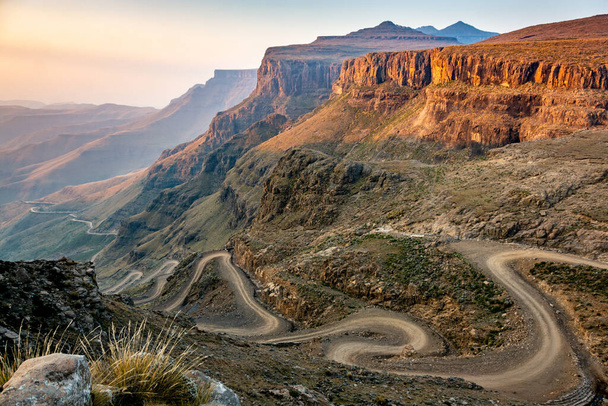 レソトへの旅行。南アフリカとレソトの間の曲がりくねった西峠未舗装道路 - 写真・画像