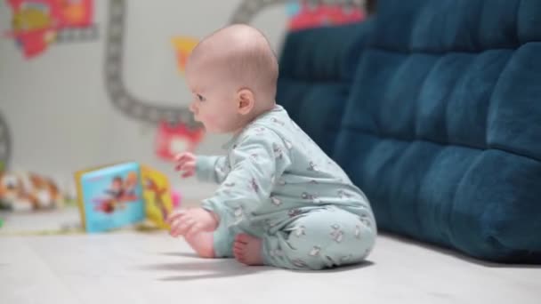 Un bebé divertido gateando dentro de casa jugando con juguetes. Bebé niño jugando con juguetes en casa. - Metraje, vídeo