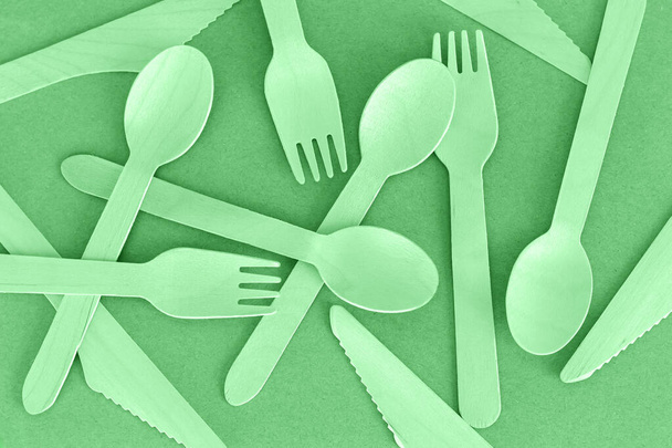 Set of eco green disposable wooden spoons, knives and forks top view. Natural biodegradable cutlery concept - Photo, Image
