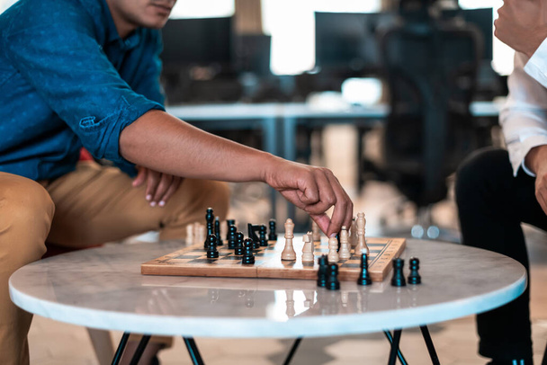 Multiethnic group of businesspeople playing chess while having a break in relaxation area at modern startup office. High-quality photo - Fotografie, Obrázek